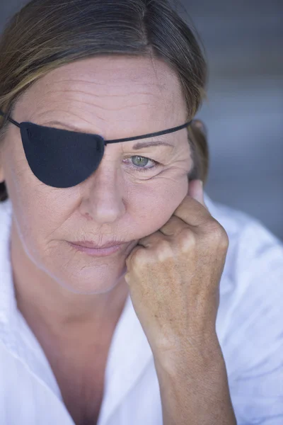 Depressed woman with eye patch portrait