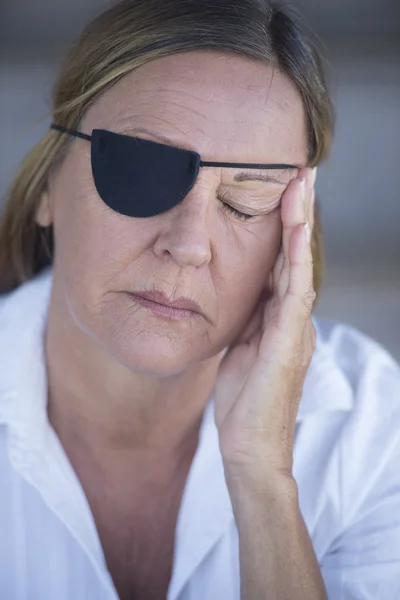 Exhausted woman with eye patch portrait