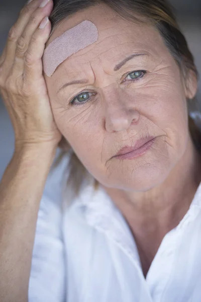 Woman with band aid suffering headache