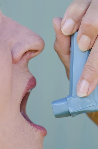 Close up woman with asthma using inhaler