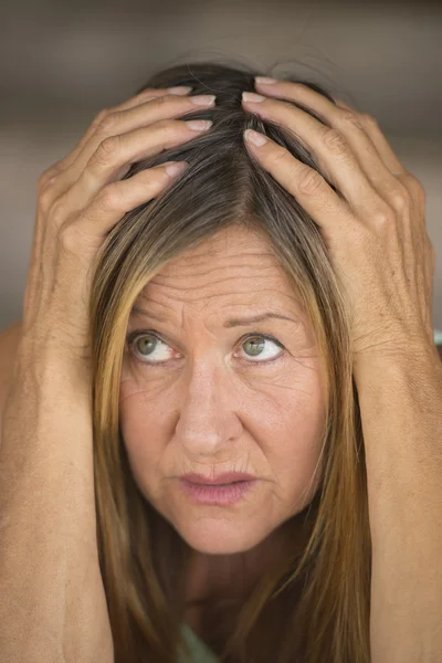 Stressed woman with hands on head