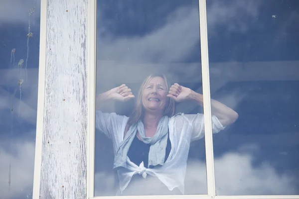 Stressed crying sad woman behind window