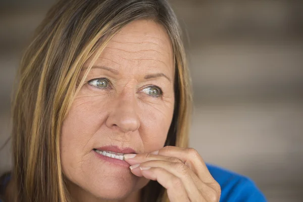 Insecure woman biting stressed finger nails