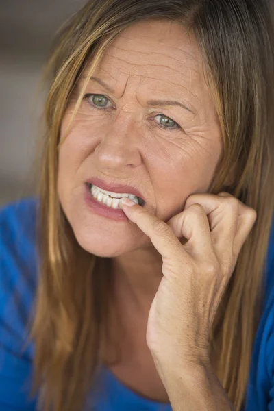 Stressed woman biting nervous finger nails