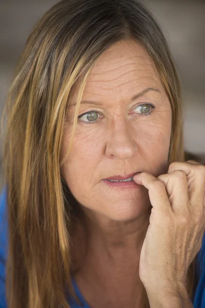 Stressed woman biting insecure finger nails