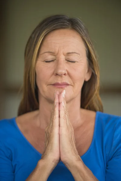 Happy Woman praying with closed eyes