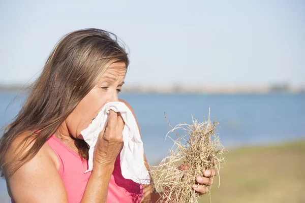 Woman outdoor in hay fever stress with tissue