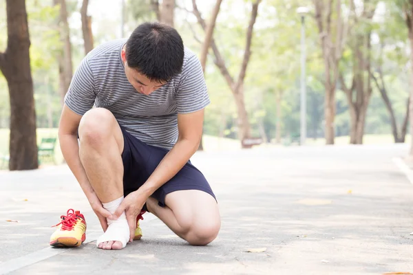 Sports injury. Man with pain in ankle while jogging