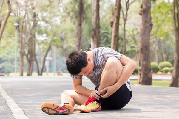 Sports injury. Man with pain in ankle while jogging