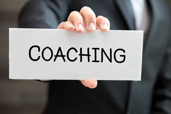 Coaching, message on white card and hold by businessman