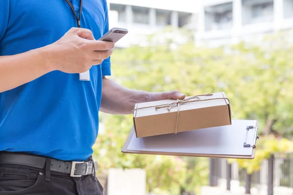 Delivery man holding a parcel box and calling contact to customer