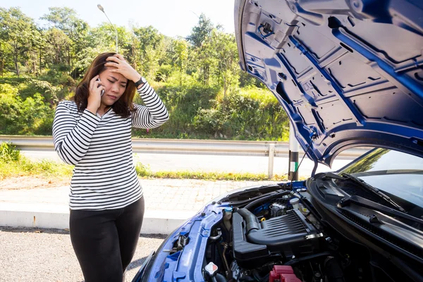 Asian women calling for assistance after breaking down car engine