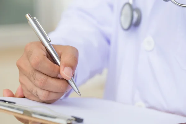 Doctor writing on clipboard