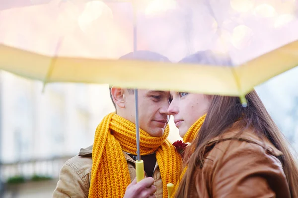 Beautiful young loving couple under an umbrella in the rain