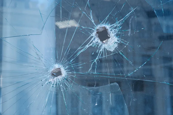 Two bullet holes in the glass windows