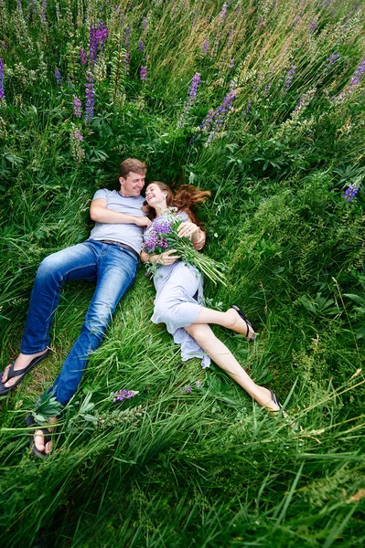 Couple in love lying in the grass on a summer meadow