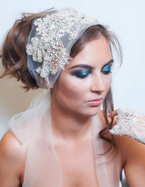 Fashion studio portrait of beautiful young bride with make up and in elegant gloves