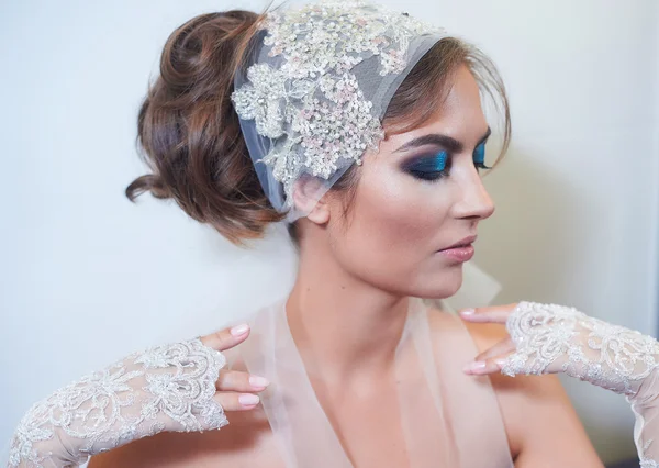 Fashion studio portrait of beautiful young bride with make up and in elegant gloves