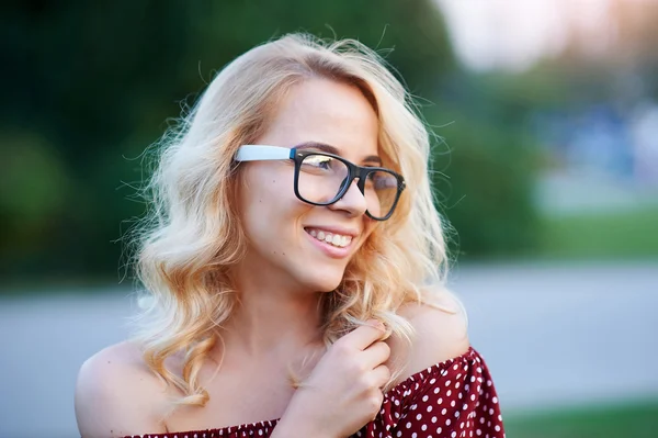 Pretty young woman in glasses posing in the park