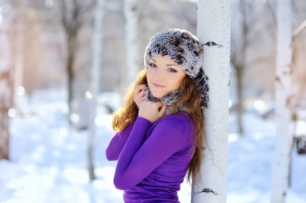 Outdoor winter portrait. Beautiful smiling girl posing in winter