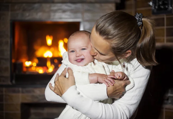 Mom and daughter kissing fireplace