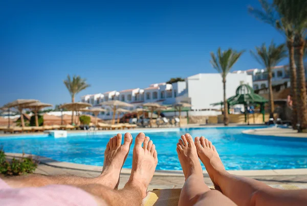 Feet resting on a background of the pool