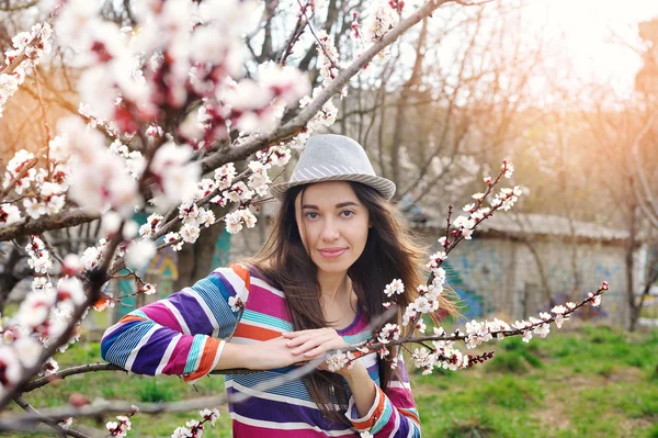 Young naturally beautiful woman near the blooming tree in spring time.