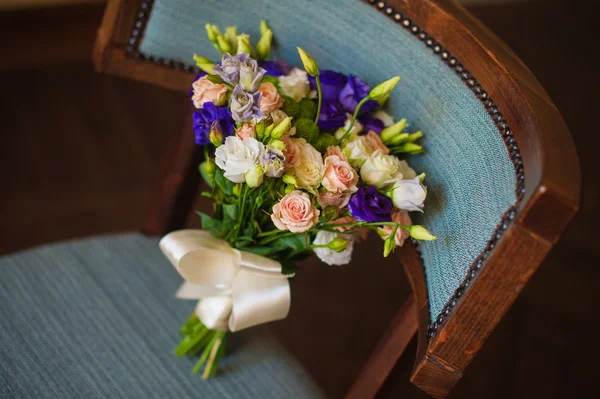 Pink and purple flowers in wedding bridal bouquet on chair