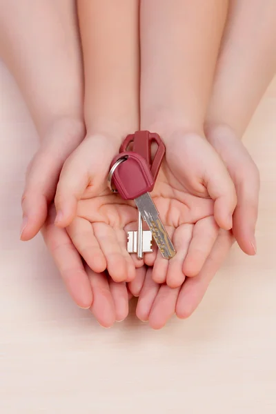 Women's hands and arms of the child hold the keys