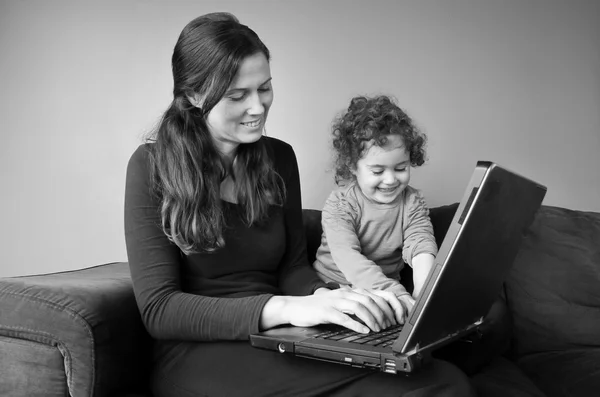 Happy mother with baby toddler works from home