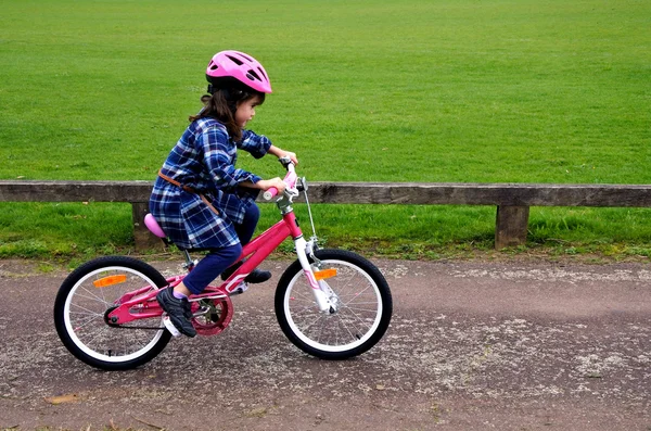 Happy little girl learns how to ride a bike