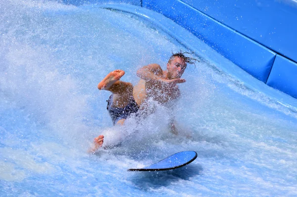 Man ride a surfing board on FlowRider