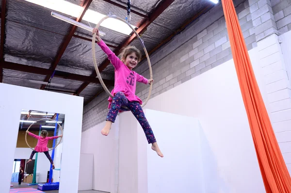 Little child learn circus skills on Aerial Lyra