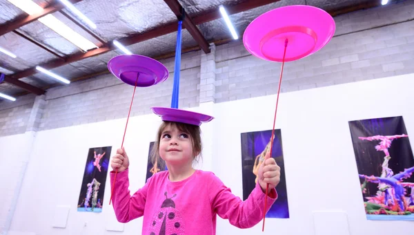 Little child learn circus skills of plate spinning