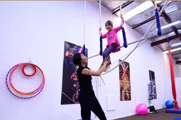 Little child learn circus skills on static trapeze  from circus