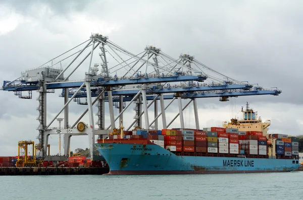 Cargo ship unloading containers in Ports of Auckland New Zealand