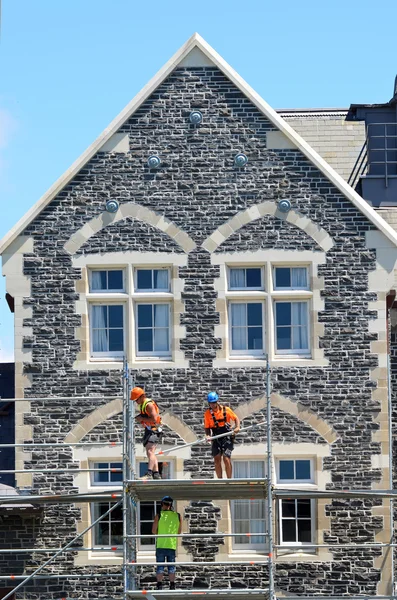 Builders fix a damaged historical building in Christchurch New Z