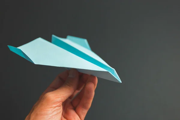 Blue paper airplane origami in hand