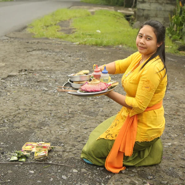 Balinese woman bring offerings of fruits and gifts to the village temple