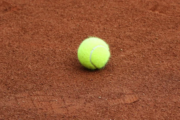 Tennis ball at red clay tennis court