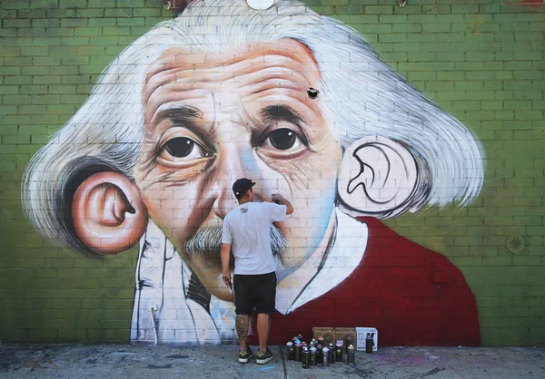 Brazilian street artist Sipros painting mural at East Williamsburg in Brooklyn.