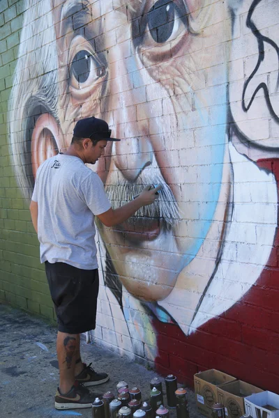 Brazilian street artist Sipros painting mural at East Williamsburg in Brooklyn.