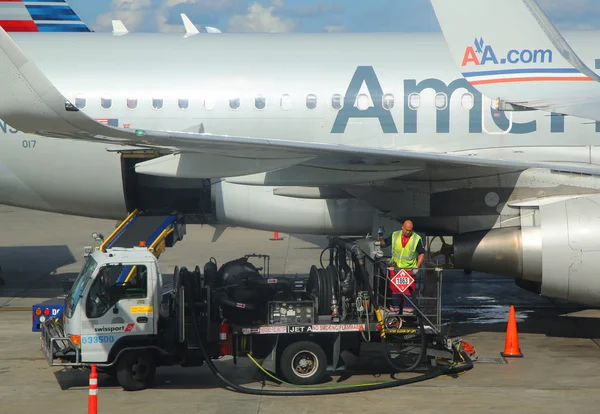 American Airlines worker refueling plane at Miami International Airport