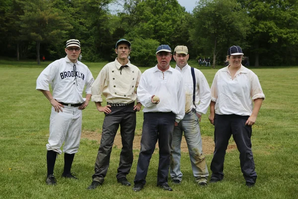 Baseball team in 19th century vintage uniform during old style base ball play following the rules and customs from 1864