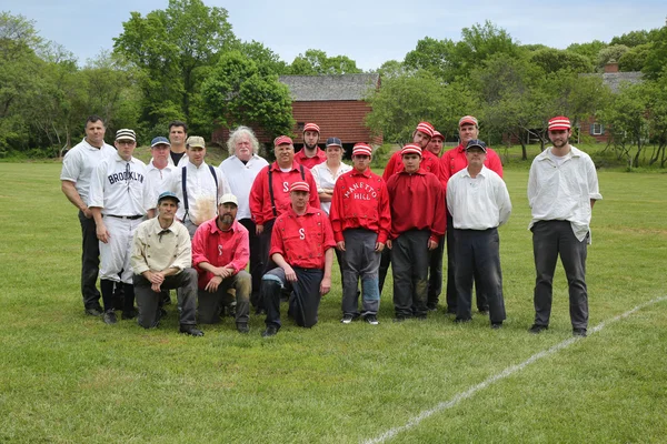 Baseball team in 19th century vintage uniform during old style base ball play following the rules and customs from 1864