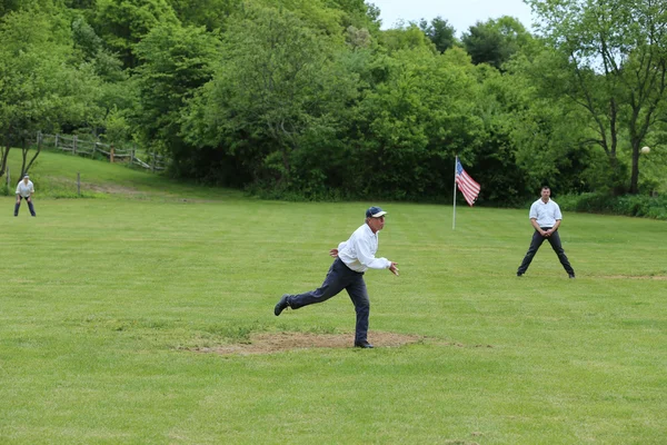 Baseball team in 19th century vintage uniform during old style base ball play following the rules and customs from 1864