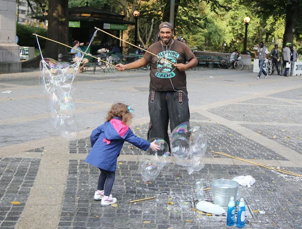 Street performer creating oversize bubbles for kids at Central Park in New York