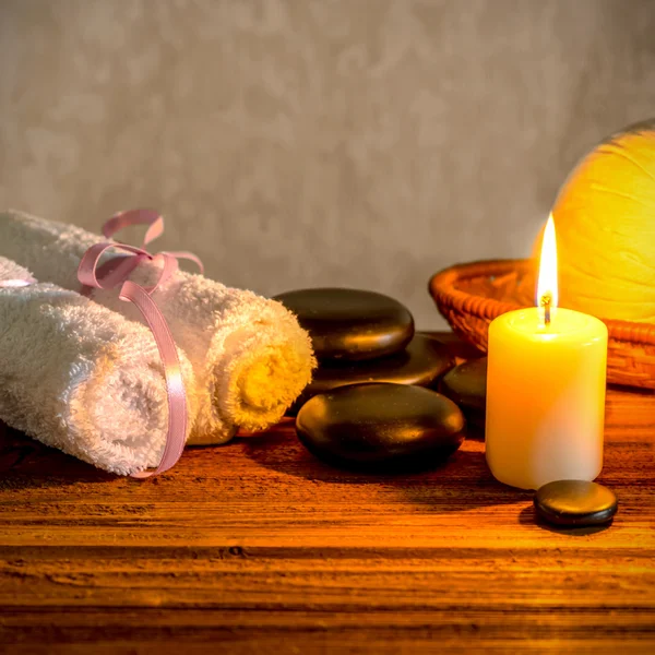 Spa still life of white towels, candle, thai herbal compress bal