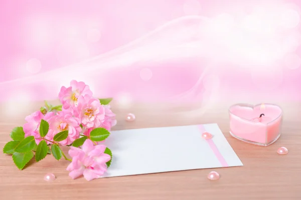 Beautiful composition of delicate pink rose, heart shaped candle