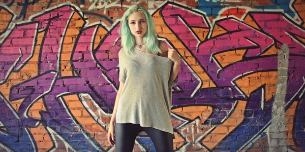 Girl posing near the wall with graffiti